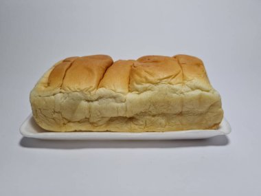 Çikolata aromalı ekmek beyaz bir kabın içinde elle parçalanabilir.