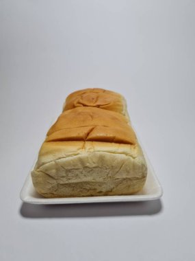 Çikolata aromalı ekmek beyaz bir kabın içinde elle parçalanabilir.