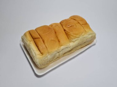 Çikolata aromalı ekmek beyaz bir kabın içinde elle parçalanabilir.