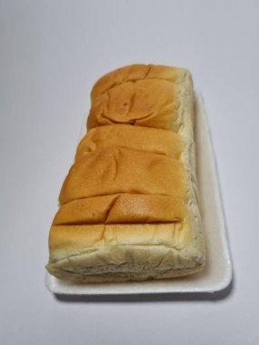 Çikolata aromalı ekmek beyaz bir kabın içinde elle parçalanabilir.