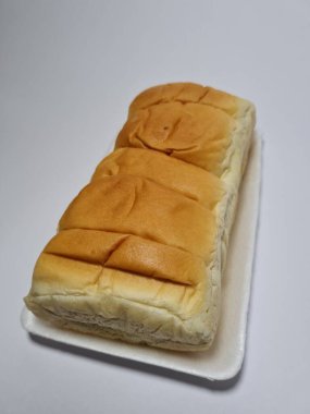 Çikolata aromalı ekmek beyaz bir kabın içinde elle parçalanabilir.