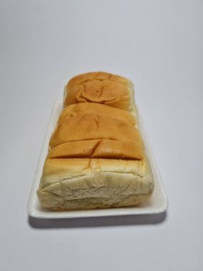 Çikolata aromalı ekmek beyaz bir kabın içinde elle parçalanabilir.