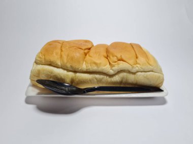 Çikolata aromalı ekmek beyaz bir kabın içinde elle parçalanabilir.