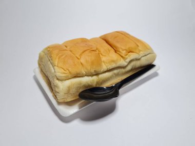 Çikolata aromalı ekmek beyaz bir kabın içinde elle parçalanabilir.