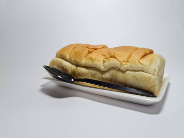 Çikolata aromalı ekmek beyaz bir kabın içinde elle parçalanabilir.