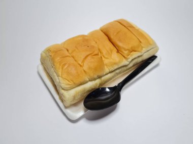 Çikolata aromalı ekmek beyaz bir kabın içinde elle parçalanabilir.