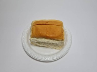 Çikolata aromalı ekmek beyaz bir kabın içinde elle parçalanabilir.