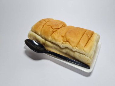 Çikolata aromalı ekmek beyaz bir kabın içinde elle parçalanabilir.