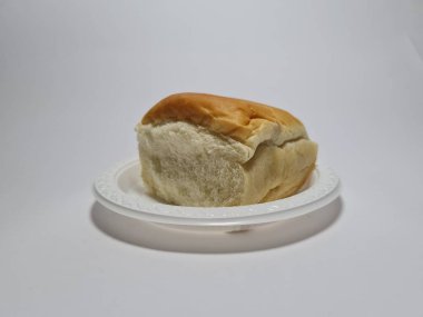 Çikolata aromalı ekmek beyaz bir kabın içinde elle parçalanabilir.