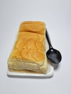 Çikolata aromalı ekmek beyaz bir kabın içinde elle parçalanabilir.