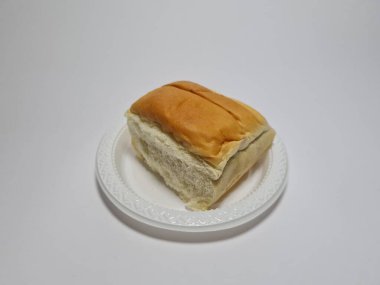 Çikolata aromalı ekmek beyaz bir kabın içinde elle parçalanabilir.