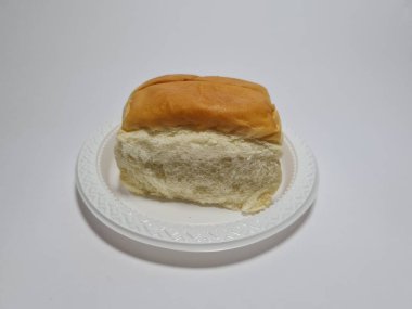 Çikolata aromalı ekmek beyaz bir kabın içinde elle parçalanabilir.