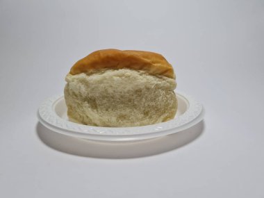 Çikolata aromalı ekmek beyaz bir kabın içinde elle parçalanabilir.