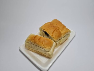 Çikolata aromalı ekmek beyaz bir kabın içinde elle parçalanabilir.