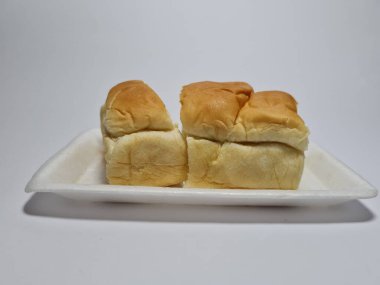 Çikolata aromalı ekmek beyaz bir kabın içinde elle parçalanabilir.