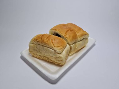 Çikolata aromalı ekmek beyaz bir kabın içinde elle parçalanabilir.