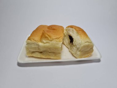 Çikolata aromalı ekmek beyaz bir kabın içinde elle parçalanabilir.