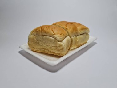 Çikolata aromalı ekmek beyaz bir kabın içinde elle parçalanabilir.