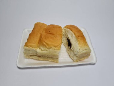 Çikolata aromalı ekmek beyaz bir kabın içinde elle parçalanabilir.