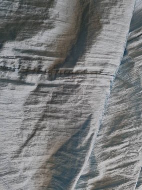 Parlak açık mavi kumaşlı, düzensiz kırışıklıkları ve gölgeleri olan soyut arkaplan kombinasyonu