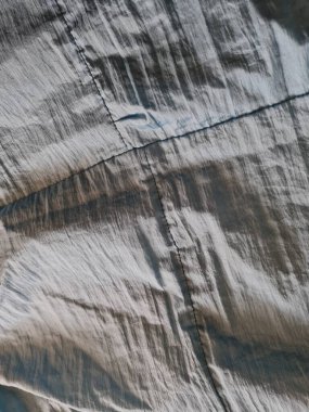 Parlak açık mavi kumaşlı, düzensiz kırışıklıkları ve gölgeleri olan soyut arkaplan kombinasyonu