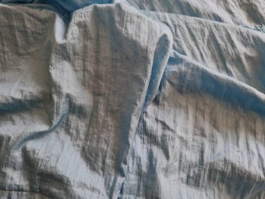 Parlak açık mavi kumaşlı, düzensiz kırışıklıkları ve gölgeleri olan soyut arkaplan kombinasyonu