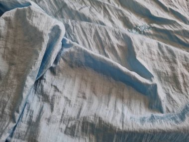 Parlak açık mavi kumaşlı, düzensiz kırışıklıkları ve gölgeleri olan soyut arkaplan kombinasyonu