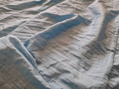 Parlak açık mavi kumaşlı, düzensiz kırışıklıkları ve gölgeleri olan soyut arkaplan kombinasyonu