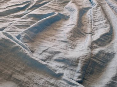 Parlak açık mavi kumaşlı, düzensiz kırışıklıkları ve gölgeleri olan soyut arkaplan kombinasyonu