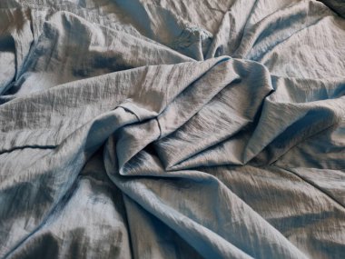 Parlak açık mavi kumaşlı, düzensiz kırışıklıkları ve gölgeleri olan soyut arkaplan kombinasyonu