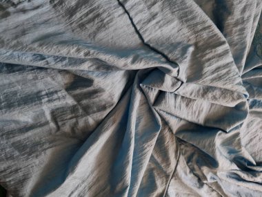 Parlak açık mavi kumaşlı, düzensiz kırışıklıkları ve gölgeleri olan soyut arkaplan kombinasyonu