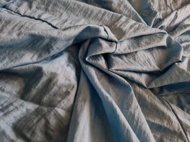 Parlak açık mavi kumaşlı, düzensiz kırışıklıkları ve gölgeleri olan soyut arkaplan kombinasyonu