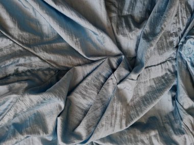 Parlak açık mavi kumaşlı, düzensiz kırışıklıkları ve gölgeleri olan soyut arkaplan kombinasyonu