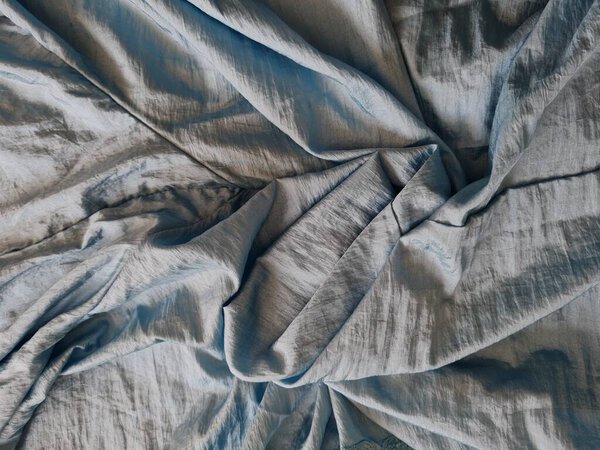 Абстрактный фон, текстурированный блеском светло-голубого цвета с неровными складками и тенями в комбинации