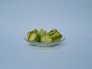 Yeşil patlıcan dilimleri beyaz ve mavi kombinasyonlarda izole edilmiş.