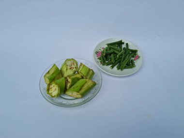 Yeşil patlıcan dilimleri ve yeşil fasulyeler beyaz ve mavi kombinasyonlarda izole edilmiş.