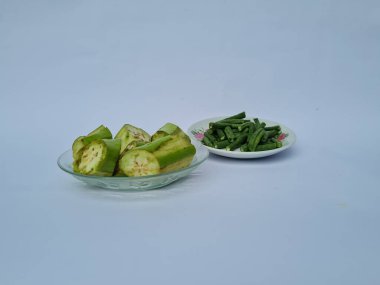 Yeşil patlıcan dilimleri ve yeşil fasulyeler beyaz ve mavi kombinasyonlarda izole edilmiş.