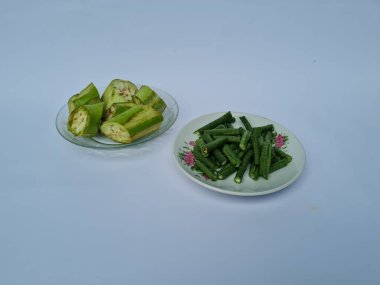 Yeşil patlıcan dilimleri ve yeşil fasulyeler beyaz ve mavi kombinasyonlarda izole edilmiş.