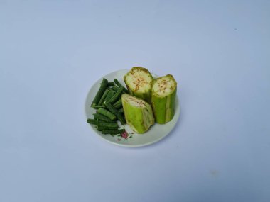 Yeşil patlıcan dilimleri ve yeşil fasulyeler beyaz ve mavi kombinasyonlarda izole edilmiş.