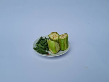 Yeşil patlıcan dilimleri ve yeşil fasulyeler beyaz ve mavi kombinasyonlarda izole edilmiş.