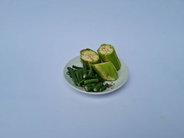 Yeşil patlıcan dilimleri ve yeşil fasulyeler beyaz ve mavi kombinasyonlarda izole edilmiş.