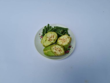 Yeşil patlıcan dilimleri ve yeşil fasulyeler beyaz ve mavi kombinasyonlarda izole edilmiş.