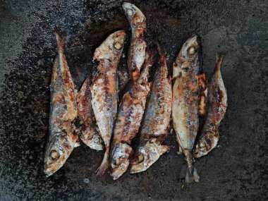 Altı baharatlı bir tavada kızarmış deniz balığı.