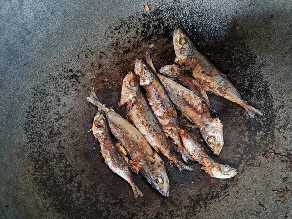 Altı baharatlı bir tavada kızarmış deniz balığı.
