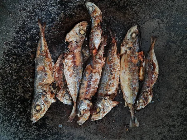 Altı baharatlı bir tavada kızarmış deniz balığı.