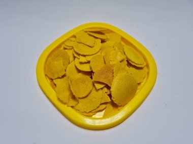 Un, şeker ve sarı bir kapta kahverengi olan diğer malzemelerden oluşan dolar denilen bir atıştırmalık.