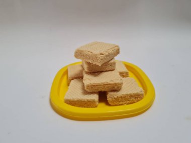 Sarı bir kabın içinde gofret adı verilen gevrek ve tatlı şekerden yapılmış atıştırmalıklar.