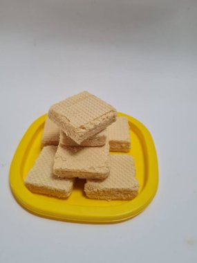 Sarı bir kabın içinde gofret adı verilen gevrek ve tatlı şekerden yapılmış atıştırmalıklar.