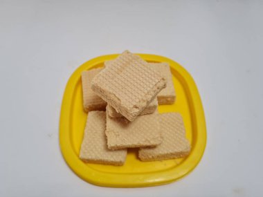 Sarı bir kabın içinde gofret adı verilen gevrek ve tatlı şekerden yapılmış atıştırmalıklar.