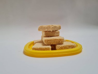 Sarı bir kabın içinde gofret adı verilen gevrek ve tatlı şekerden yapılmış atıştırmalıklar.